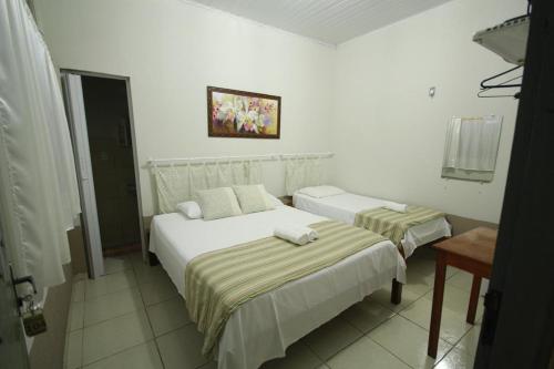 Łóżko lub łóżka w pokoju w obiekcie Rochas pousada