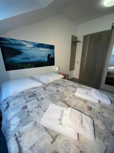 a bedroom with a large bed with towels on it at Natalii in Kudowa-Zdrój