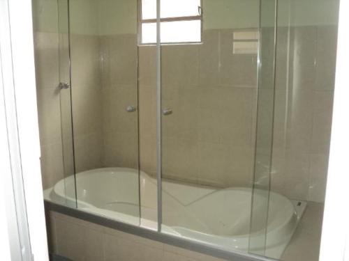 a glass shower in a bathroom with a tub at Rochas pousada in Carolina