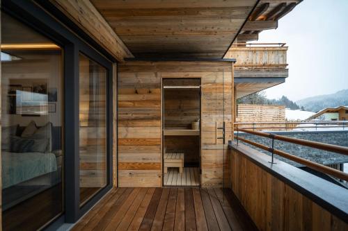 a wooden balcony of a house with a bedroom at Big Seven Ferienwohnungen Seiwald in Fieberbrunn