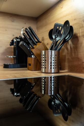 a shelf with knives and utensils on it at Big Seven Ferienwohnungen Seiwald in Fieberbrunn