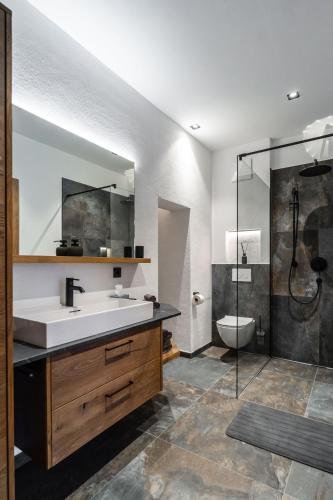 a bathroom with a sink and a shower and a toilet at Big Seven Ferienwohnungen Seiwald in Fieberbrunn