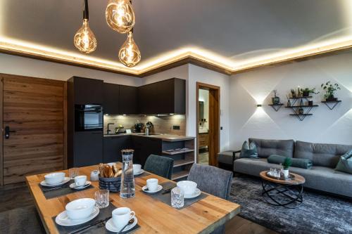 a living room with a table and a couch at Big Seven Ferienwohnungen Seiwald in Fieberbrunn