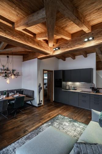 an open kitchen and living room with wooden ceilings at Big Seven Ferienwohnungen Seiwald in Fieberbrunn