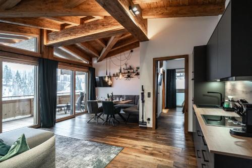a kitchen and living room with wooden ceilings at Big Seven Ferienwohnungen Seiwald in Fieberbrunn