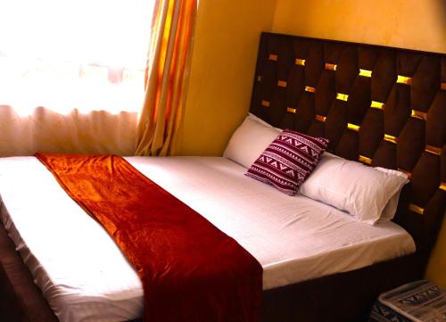 łóżko w pokoju z oknem w obiekcie Mahnoor Airbnb Mombasa w mieście Mombasa