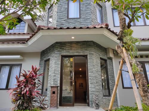 a home with a stone house with a front door at Wyndham Garden Yogyakarta in Sleman
