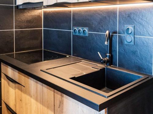 Una cocina con fregadero y una pared azul. en Appartement montagne rénové, 6 pers, proche pistes et commodités - FR-1-637-59, en Val Thorens