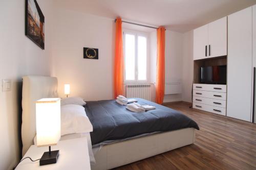um quarto com uma cama, uma televisão e cortinas cor de laranja em the house outside the walls em Siena