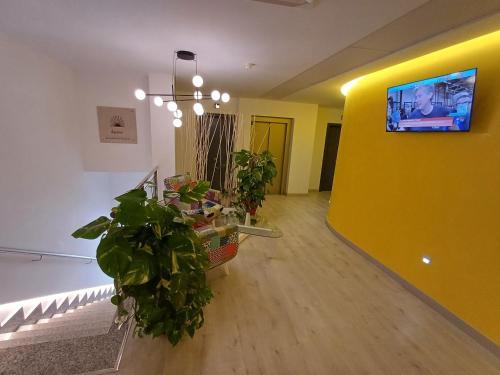ein Wohnzimmer mit Pflanzen und einer gelben Wand in der Unterkunft Aureo Alojamiento Urbano in Abarán