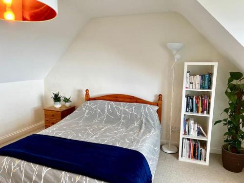 een slaapkamer met een bed en een boekenplank bij Comfortable, modern family home in St. Agnes in St. Agnes 