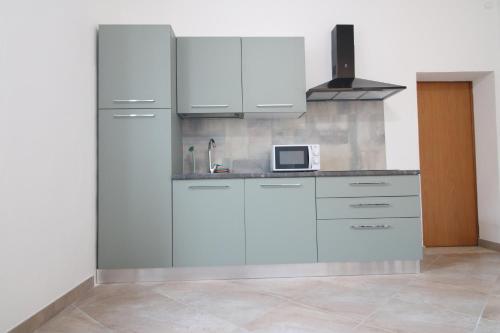 uma cozinha com armários brancos e um micro-ondas em the house outside the walls em Siena
