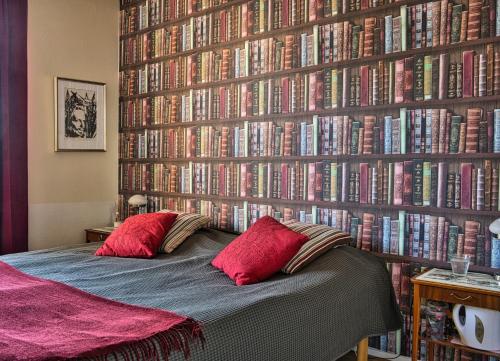 a bedroom with a wall full of books at Bed and books på Österlens Gästhärbärge in Glemminge