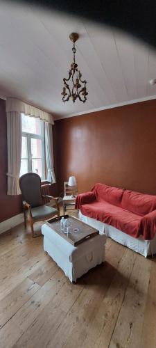 1 dormitorio con cama roja y mesa en Heerlijke Studio in centrum van Brugge, en Brujas