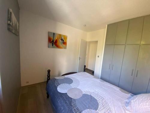 une chambre avec un lit avec un couvre-lit bleu et blanc dans l'établissement Appartement, au cœur de Sallanches, à Sallanches