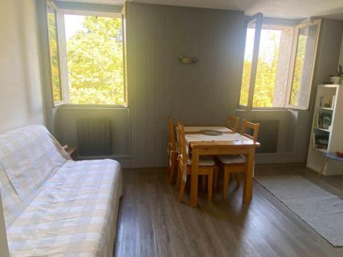 une pièce avec une table, des chaises et un lit dans l'établissement Appartement, au cœur de Sallanches, à Sallanches