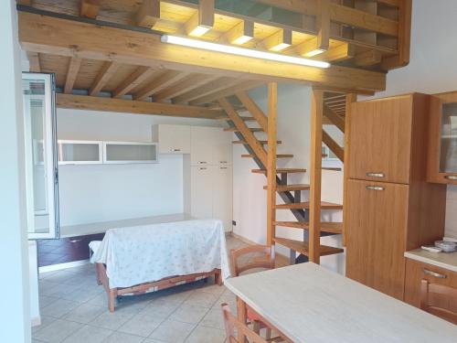 a room with a table and a kitchen with a ladder at Appartamento in Piazza in Moniga