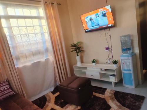 a living room with a tv on the wall at Mahnoor Airbnb Mombasa in Mombasa