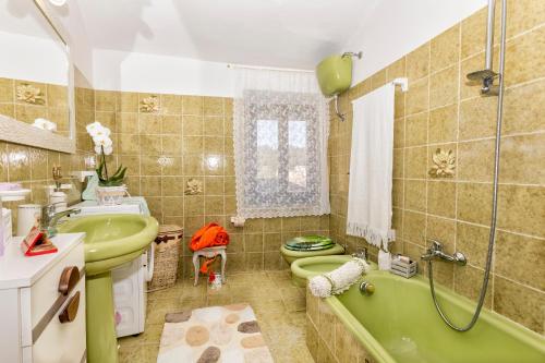 bagno con vasca verde, servizi igienici e lavandino di Villa Viola a Chianciano Terme