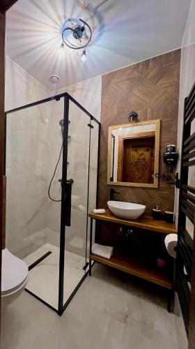 a bathroom with a glass shower and a sink at Rozeta in Witów