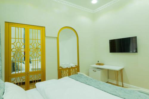 a bedroom with a bed and a table and a tv at Marita Hotel in Tbilisi City