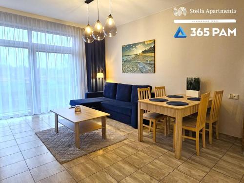 a living room with a blue couch and a table at 365PAM - Szum Morza - Apartament w Diune in Kołobrzeg