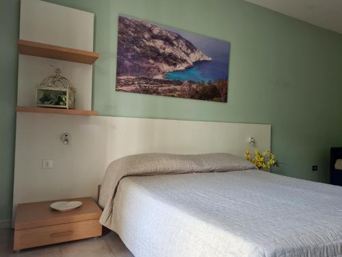 a bedroom with a bed and a picture on the wall at Hotel La Buca Del Gatto in Marina di Cecina