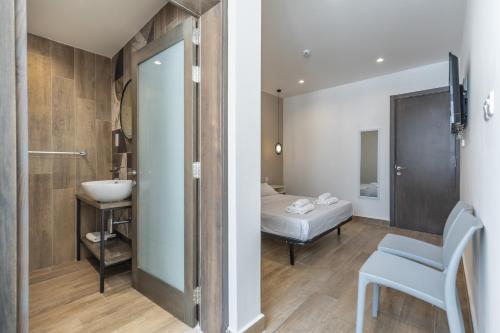 a bathroom with a sink and a bed in a room at Well located studio 12 with kitchen and backyard in Paceville