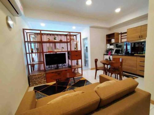 a living room with a couch and a kitchen at TimurBay Seafront ZarZyra Suite in Kuantan