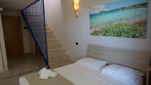 a bedroom with a bed and a stair case at Hotel La Buca Del Gatto in Marina di Cecina