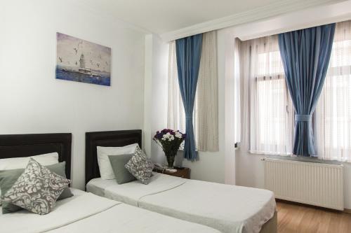 a bedroom with two beds and blue curtains at The House of Tulpan in Istanbul