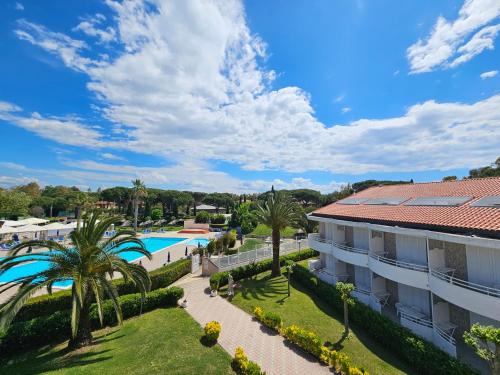 vista su un resort con piscina e palme di Hotel La Buca Del Gatto a Marina di Cecina
