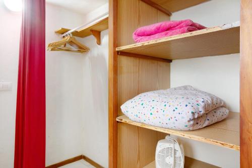 un armario con estanterías de madera y una almohada en Welcome in Paradise en La Matanza de Acentejo
