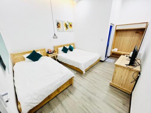 Pokój z dwoma łóżkami i telewizorem w obiekcie D'Villa Hotel - Homestay w mieście Kon Tum