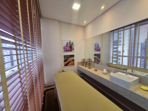 ein Badezimmer mit einem Waschbecken und einem großen Fenster in der Unterkunft JH PALHANO in Londrina