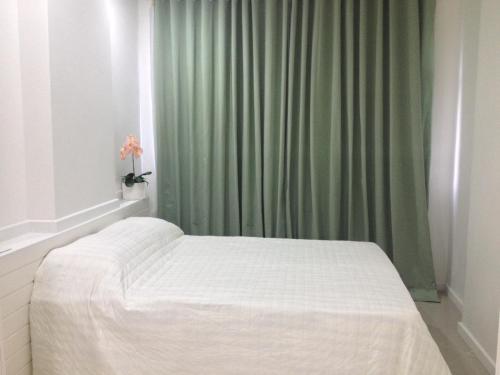uma cama num quarto com uma cortina verde em PJ160 no Rio de Janeiro