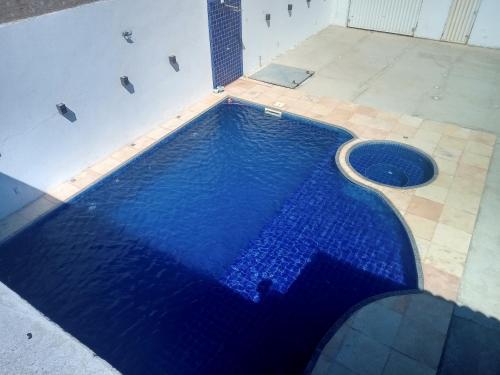 uma piscina com água azul num edifício em Casa com Piscina, hidromassagem e churrasqueira. em Canoa Quebrada