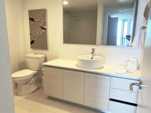 ein Badezimmer mit einem Waschbecken, einem WC und einem Spiegel in der Unterkunft Miami Beach 1B/1B Incredible View apartment with Kitchen in Hallandale Beach
