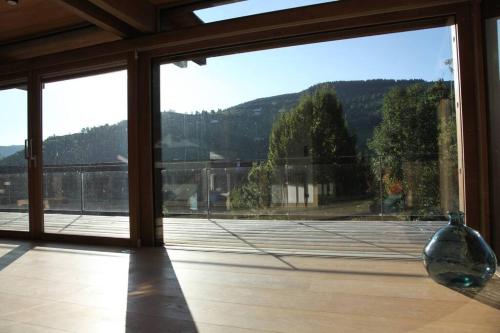 uma grande janela de vidro com vista para um campo de ténis em Chalet Fleur des Vosges 5 Bedrooms em La Bresse