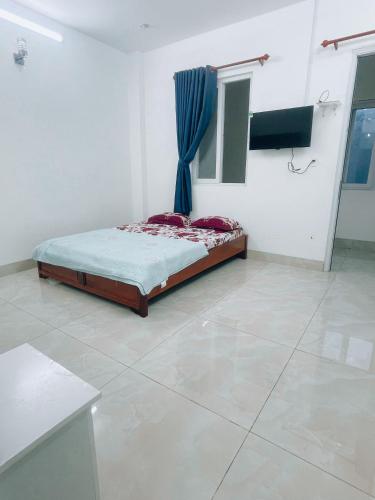 1 dormitorio con 1 cama con cortina azul en HOATEL MEKONG HOME GUESTHOUSE, en Can Tho