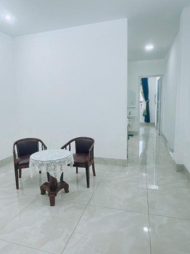 Habitación blanca con mesa y 2 sillas en HOATEL MEKONG HOME GUESTHOUSE, en Can Tho