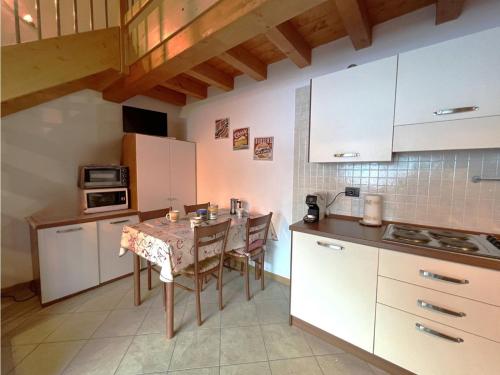 a kitchen with a table and a small kitchen with white cabinets at Affittimoderni San Simone - VALS30 in Valleve