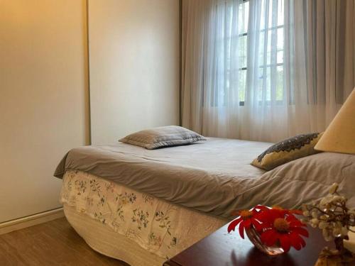 um quarto com uma cama, uma janela e uma mesa em Casa Rosa Hospedaria em Araxá