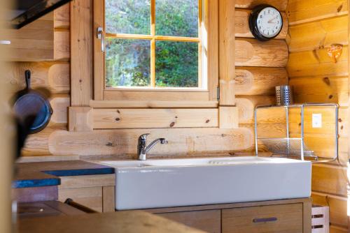 a kitchen with a sink and a clock on the wall at AlpenRose - 8 pers - avec cachet -pres des pistes in Plan Fey