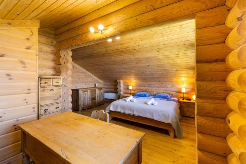 a bedroom with a bed in a log cabin at AlpenRose - 8 pers - avec cachet -pres des pistes in Plan Fey