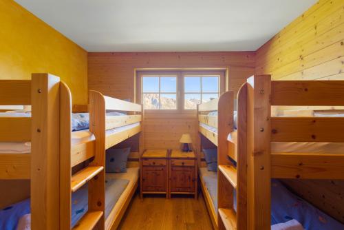 a room with four bunk beds and a window at AlpenRose - 8 pers - avec cachet -pres des pistes in Plan Fey