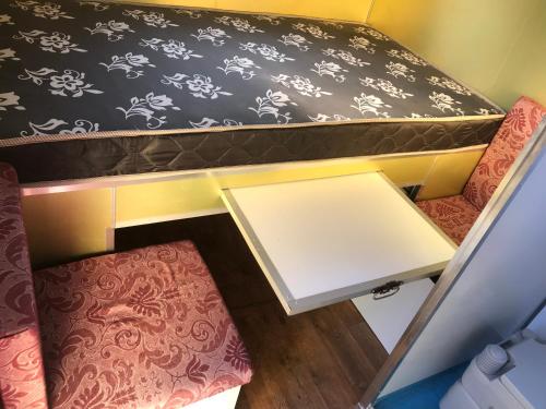 um quarto com uma mesa e duas cadeiras num reboque em Trailer Refúgio Shakti em Florianópolis