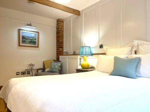 1 dormitorio con 1 cama blanca grande y 1 silla en Hedges House en Buckingham