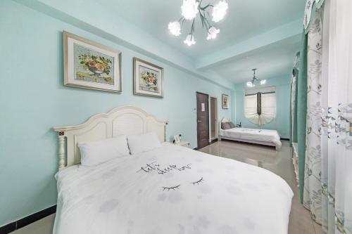 ein Schlafzimmer mit einem großen weißen Bett in einem Zimmer in der Unterkunft XICHI Homestay in Jinning