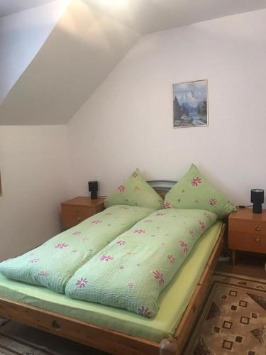 a bed with a green comforter in a bedroom at Casa Stana in Cavnic